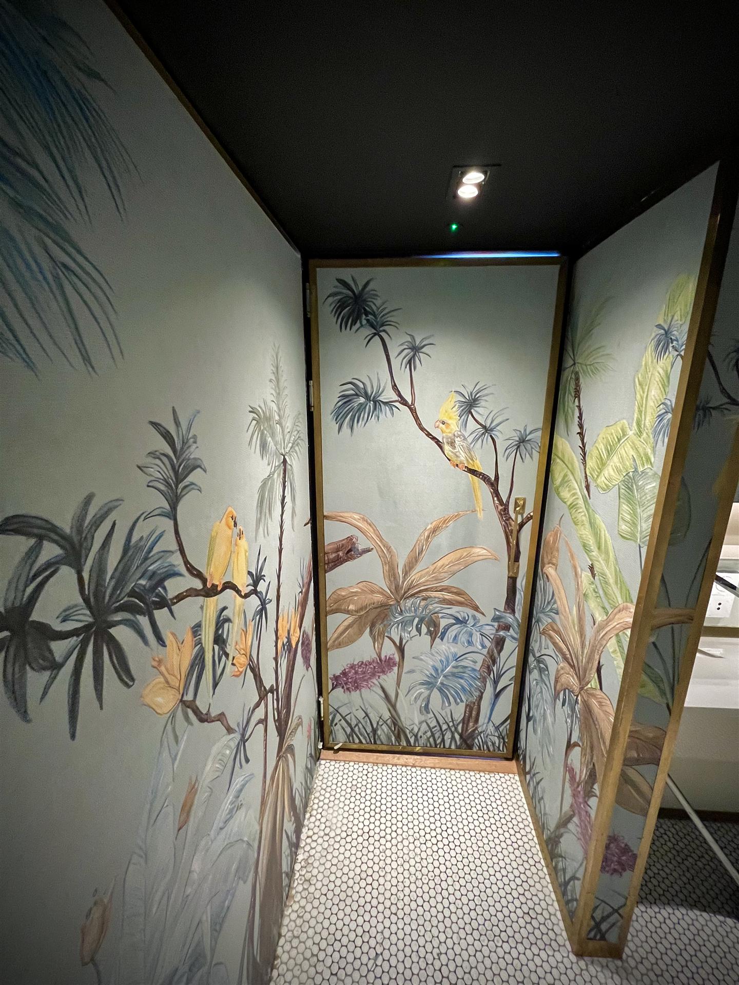 Finished tropical botanical wallpaper in toilet cubicle, London